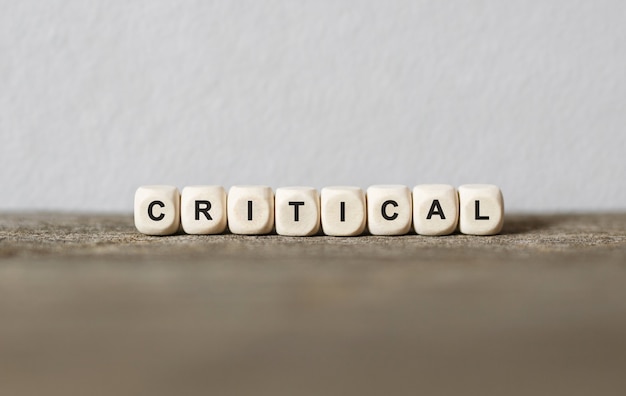 Word CRITICAL made with wood building blocks