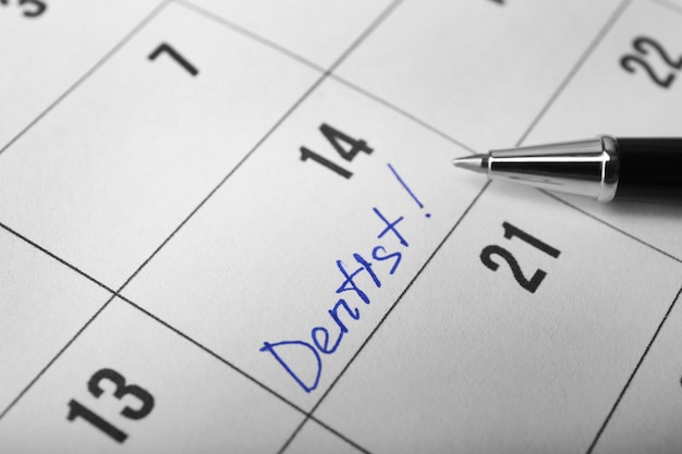 Фото Слово дентист в календаре и ручке крупным планом