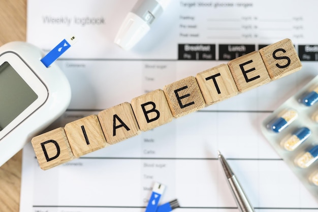 Word DIABETES는 의료용 알약 글루코미터 및 혈당 검사와 함께 나무 정육면체에서 조립되었습니다.