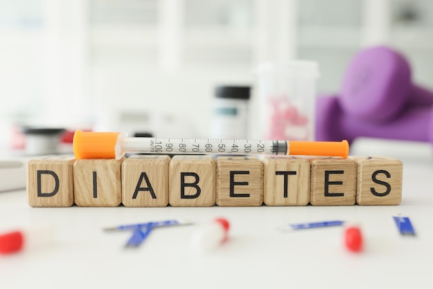 Word diabetes made with wooden cubes and syringe on table chronic endocrine disease caused by