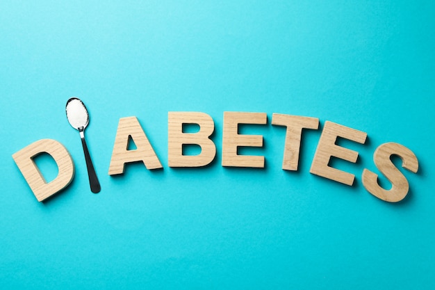 Word Diabetes made of wooden letters on turquoise table