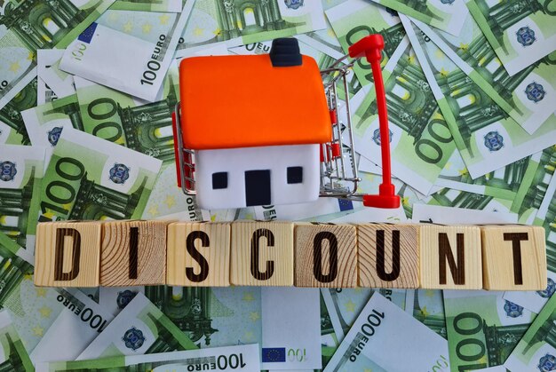 Casa di sconto di parola e carrello della spesa sulle banconote in euro