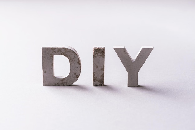Word diy from cement letters on grey background Do It Yourself abrreviation