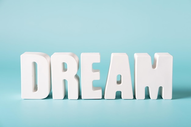 Word Dream made from white concrete letters on the blue background