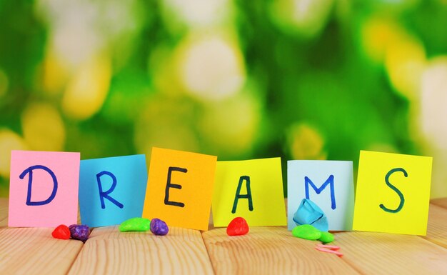 The word "Dreams" on wooden table on natural background