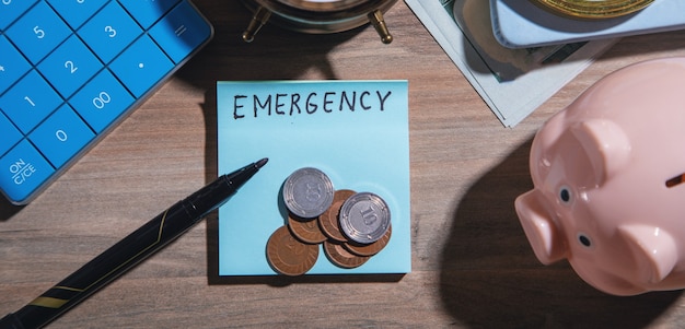 Word Emergency with a coins, marker, piggy bank.