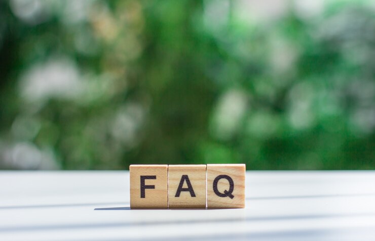 ソフトフォーカスの緑の葉を背景にライトテーブル上の木製の立方体の単語FAQメッセージサインよくある質問の概念
