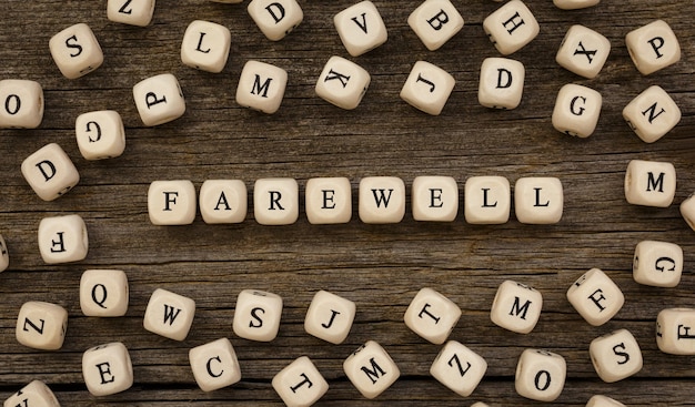 Word FAREWELL written on wood block