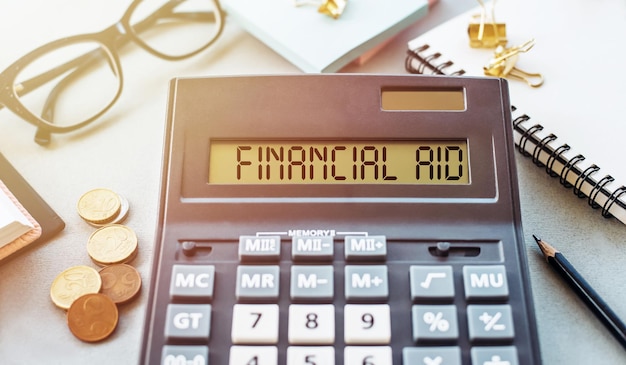 Word FINANCIAL AID written on calculator on office table