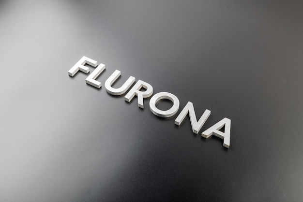 The word flurona laid with silver metal letters on gloss black background