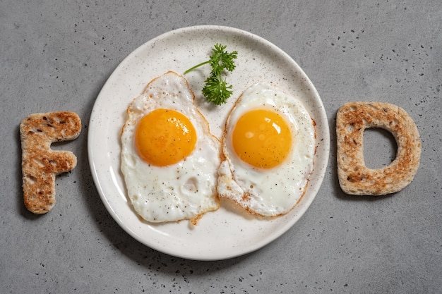 Word food written with toast letters fried eggs