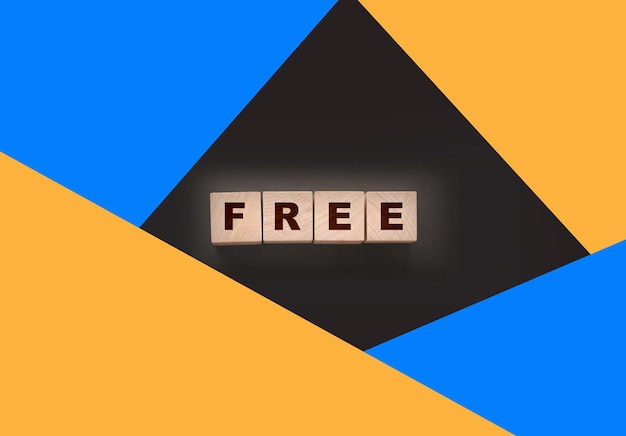 the word free on wooden blocks on black background Business concept