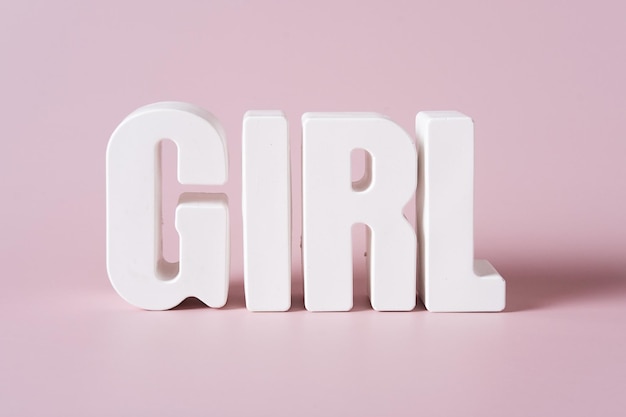 Word Girl gemaakt van witte betonnen letters op de roze achtergrond