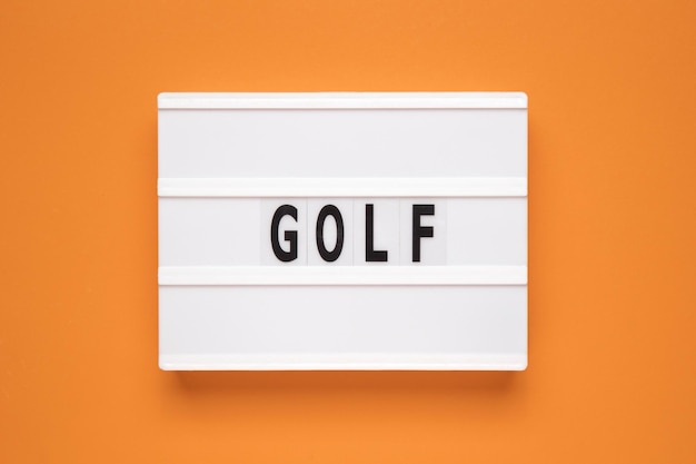 라이트박스에 있는 단어 골프는 주황색 배경에 고립되었습니다.