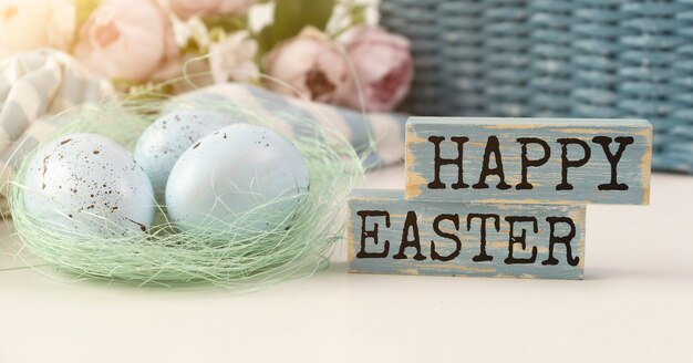 Word Happy Easter. The phrase is laid out in wooden letters. Top view. Motivation. Blue. The minimum concept of Easter.