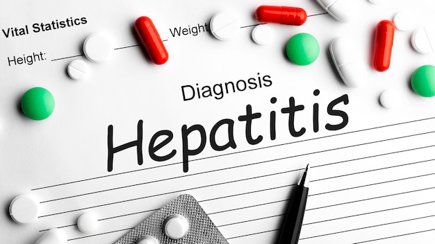 사진 펜, 여러 약품 알약, 정제 및 캡슐이 있는 종이에 hepatis라는 단어