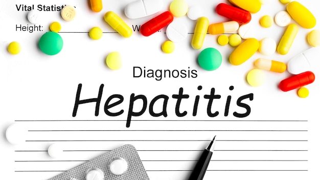 사진 펜, 여러 약품 알약, 정제 및 캡슐이 있는 종이에 hepatis라는 단어