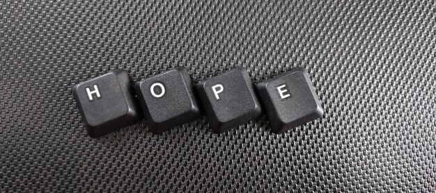 The word hope written with black computer keys on a black background