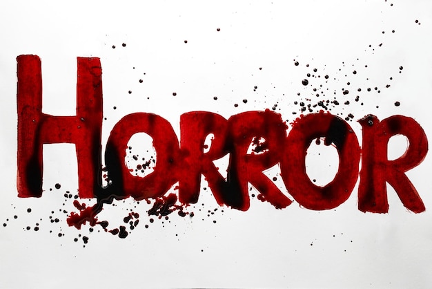 Word Horror written by blood. Halloween, abuse, destruction concept