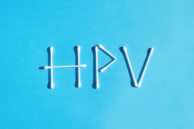 La parola human papiloma virus hpv è foderata con bastoncini di cotone su sfondo blu