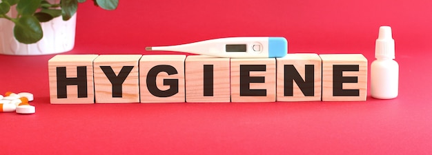 Word HYGIENE made of wooden cubes on a red background