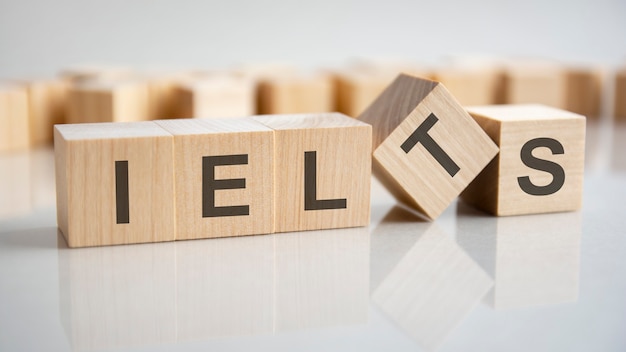 Word IELTS on wooden cubes, gray background