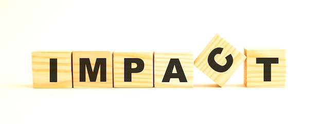 The word IMPACT. Wooden cubes with letters isolated on white surface.