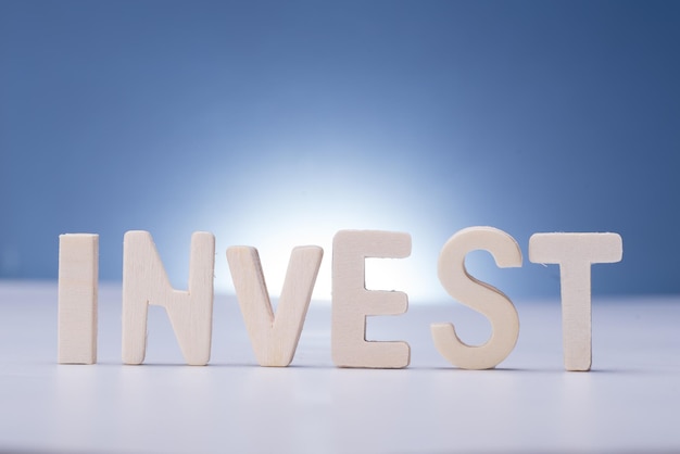 Photo the word invest isolated over blue