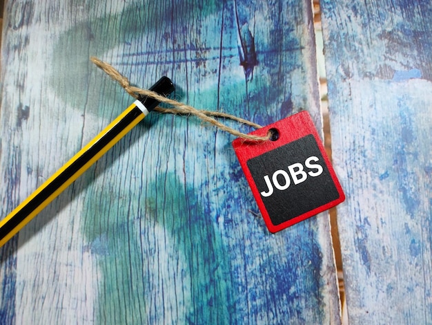 Foto word jobs op een houten bord met potlood op blauwe houten tafel achtergrond bedrijfsconcept