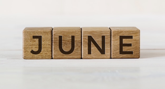 The word June on wooden cubes. Concept Month of year.