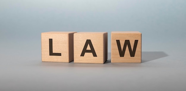 Word LAW on wooden cubes on grey blue background