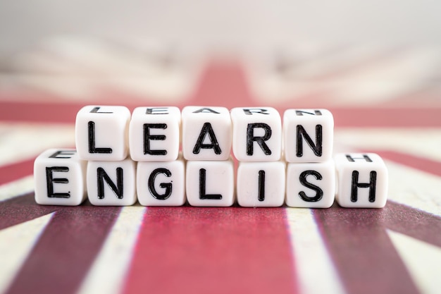 Word Learn English on book with United Kingdom flag learning English language courses concept