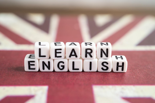 Photo word learn english on book with united kingdom flag learning english language courses concept