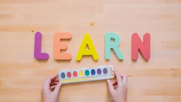 Word LEREN van veelkleurige houten letters op houten tafel.