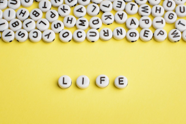 The word LIFE made of white plastic blocks with many letters on the top