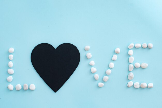 Word love on a blue background with white pebbles