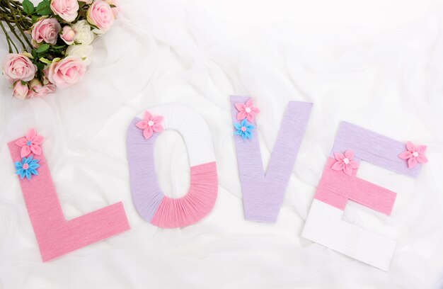 Word Love created with brightly colored knitting yard on fabric background