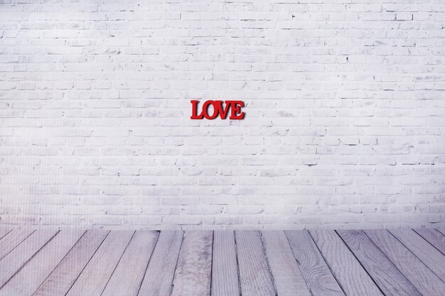 Word love from Wooden letters on the wall of white brick background