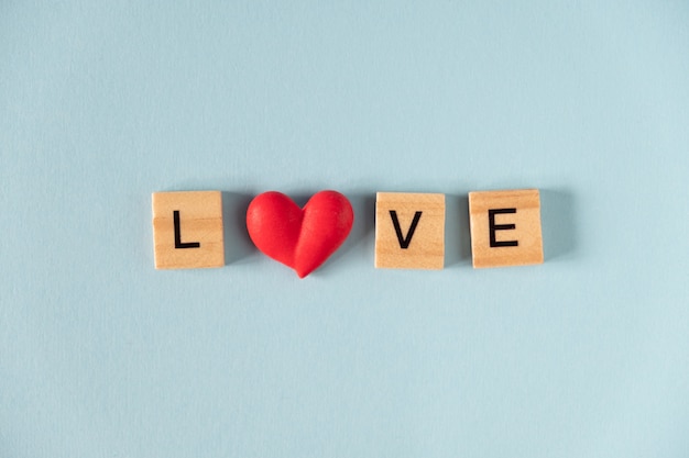 Word love and heart on blue background