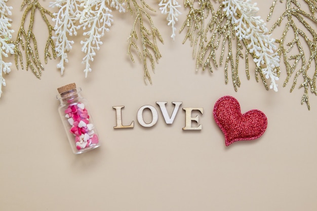 Word love houten letters met rood hart en twijgen