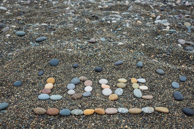 모래 해변에서 돌로 만든 단어 사랑