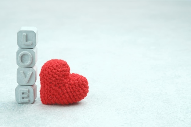 Word Love made of gray concrete letters Crochet red heart Valentine's Day