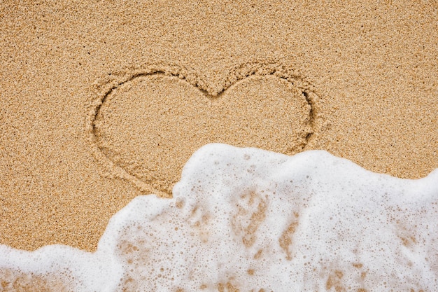 Foto la parola amore nel mare sulla spiaggia primo piano