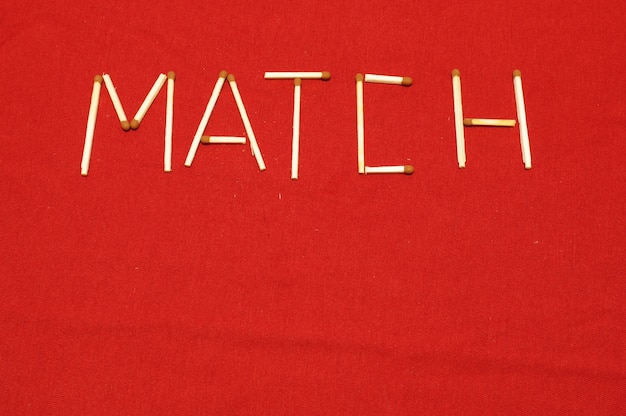 The word "Match" consists of matches on a red cloth background.