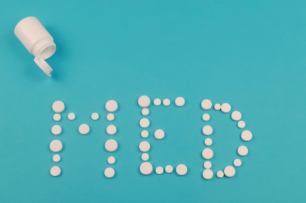 Word Med made of pills on blue background