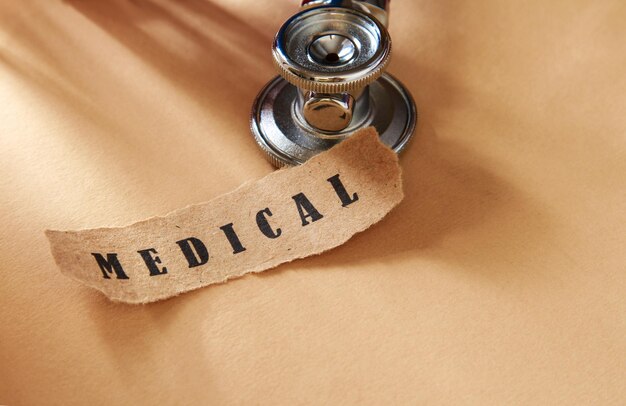 Word medical written on a ripped piece of paper and astethoscope