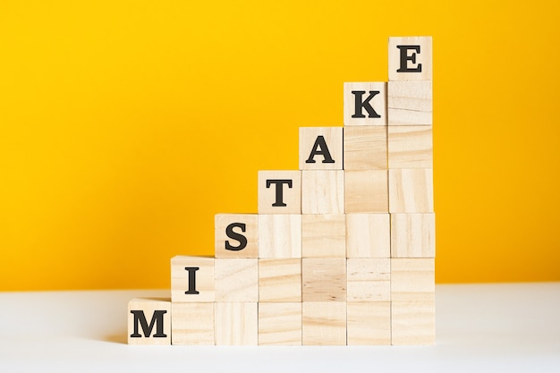 The word mistake is written on a wooden cubes. Corporate hierarchy concept and multilevel marketing.