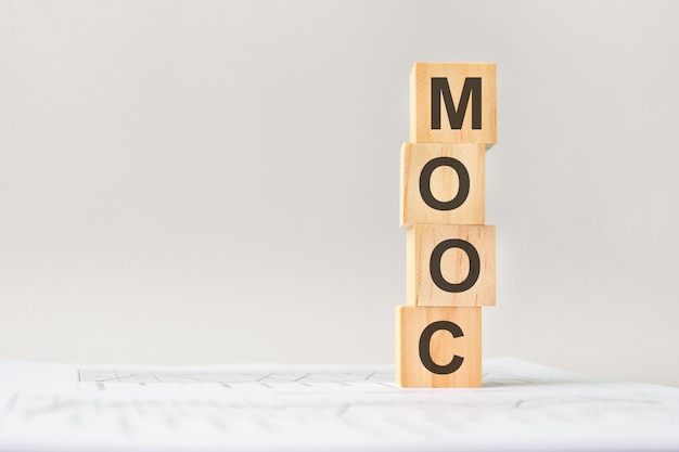 Word MOOC op houten blokken, grijze achtergrond, bedrijfsconcept. zaken en financiën