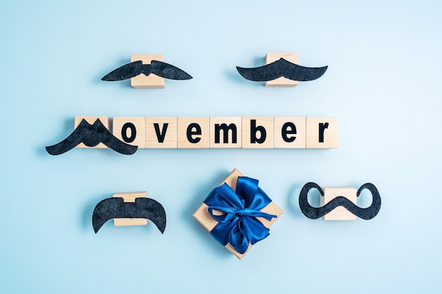 Фото Слово movember и усы на синем фоне