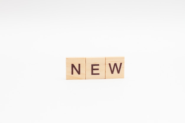 The word NEW is made of wooden cubes isolated